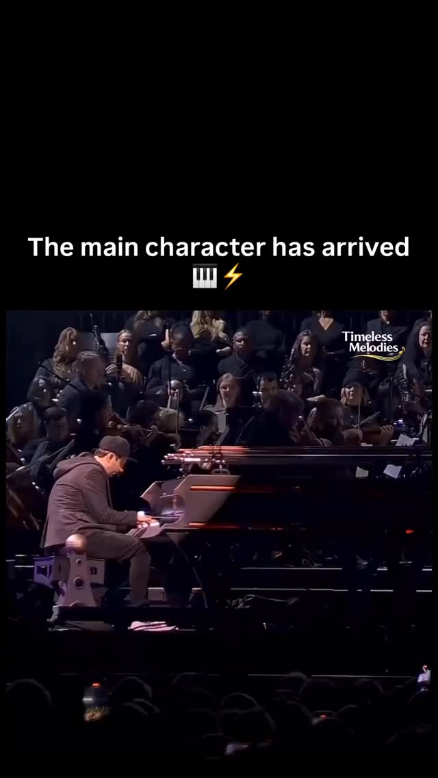 Pianist performing with a full orchestra, captioned “The main character has arrived”