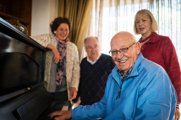 Smiling older pianist playing with companions nearby