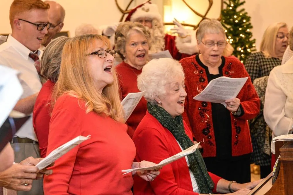 Seniors and community members singing together during a holiday music program.